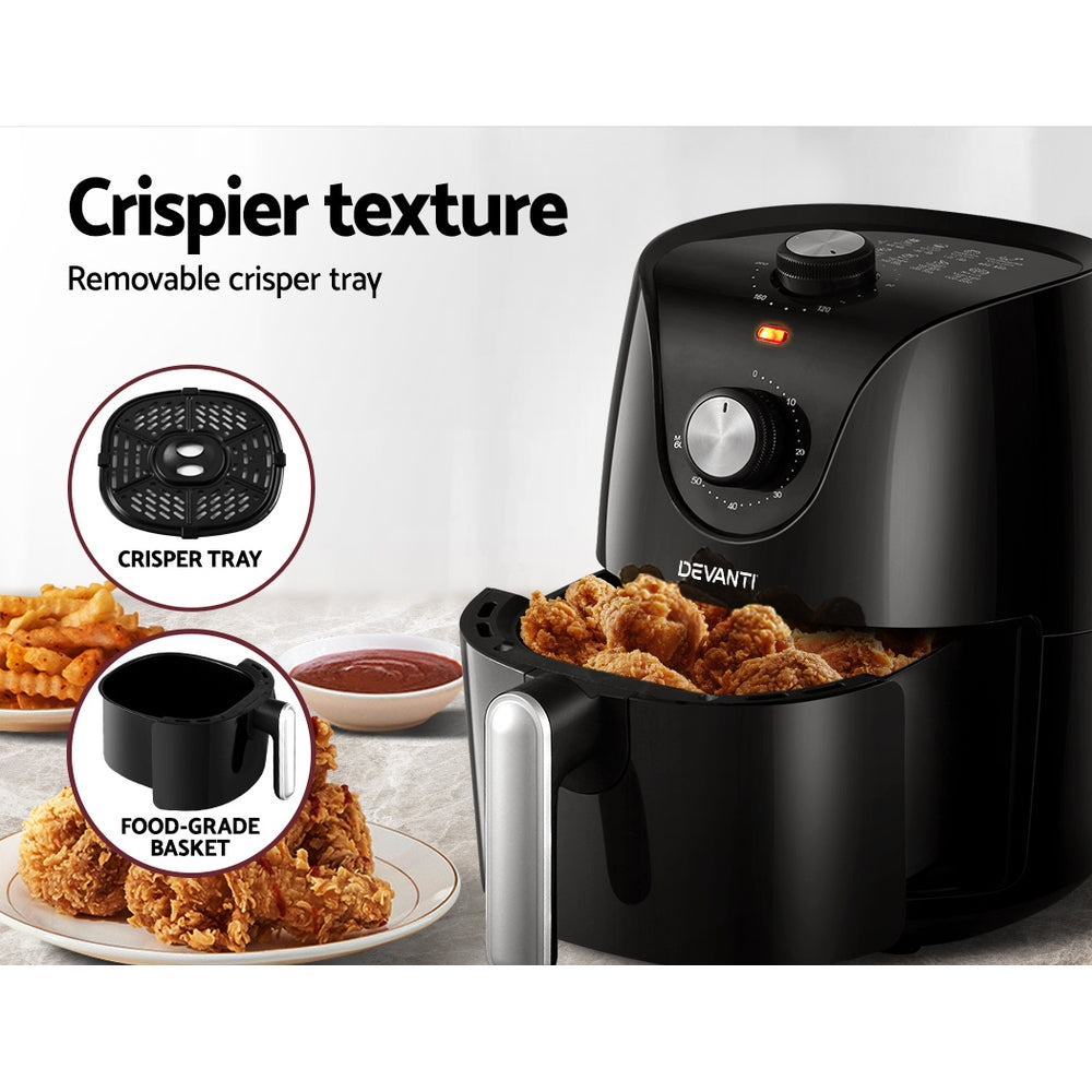 Black air fryer with removable crisper tray and food-grade basket, showing crispy fried chicken and a bowl of sauce.