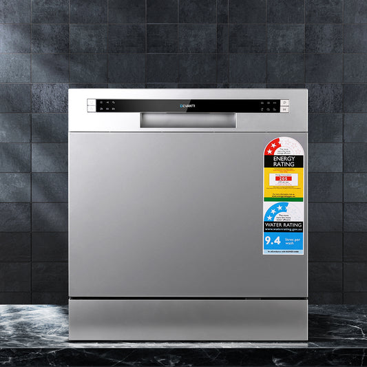 Stainless steel dishwasher with energy and water rating labels on a dark tiled wall background