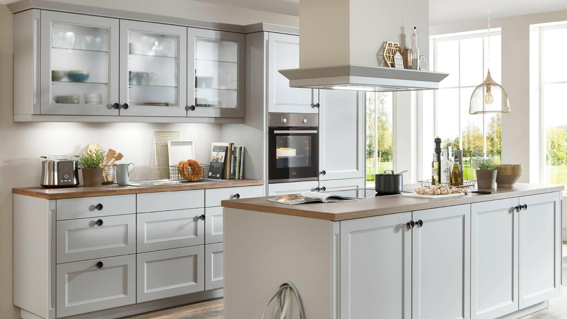 Modern kitchen with white cabinets, wooden countertops, and stainless steel appliances.