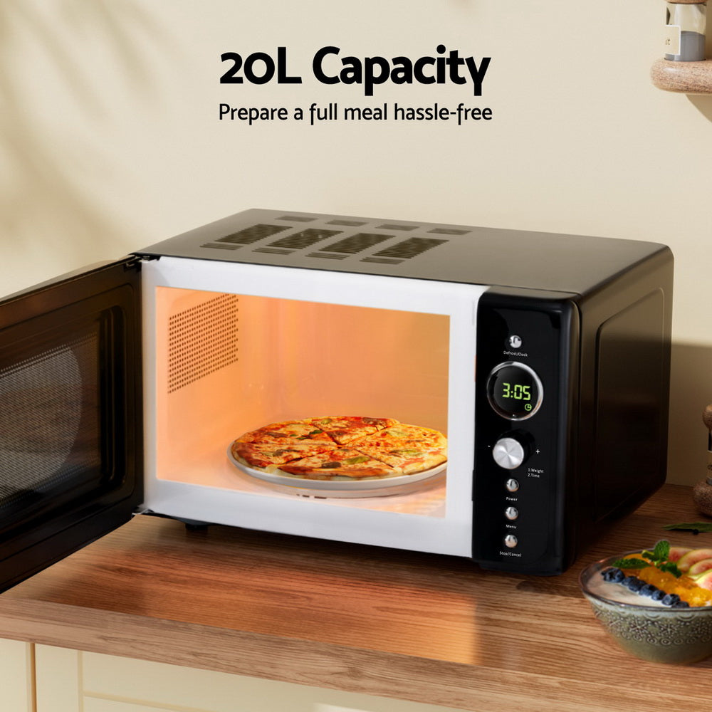 Devanti 700W microwave with food plate inside, showcasing meal prep convenience.
