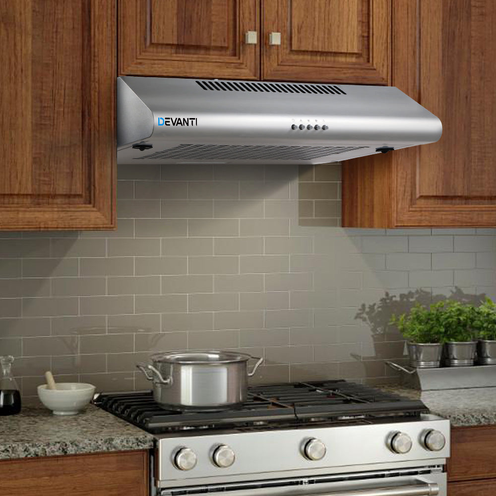 Stylish modern kitchen scene with model, showcasing the installed Devanti stainless steel range hood in use