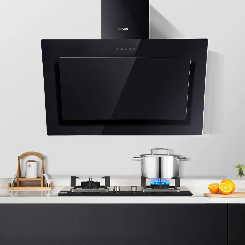 Full kitchen installation showing the Devanti angled black range hood mounted above a stove. Model RH-90-BK.