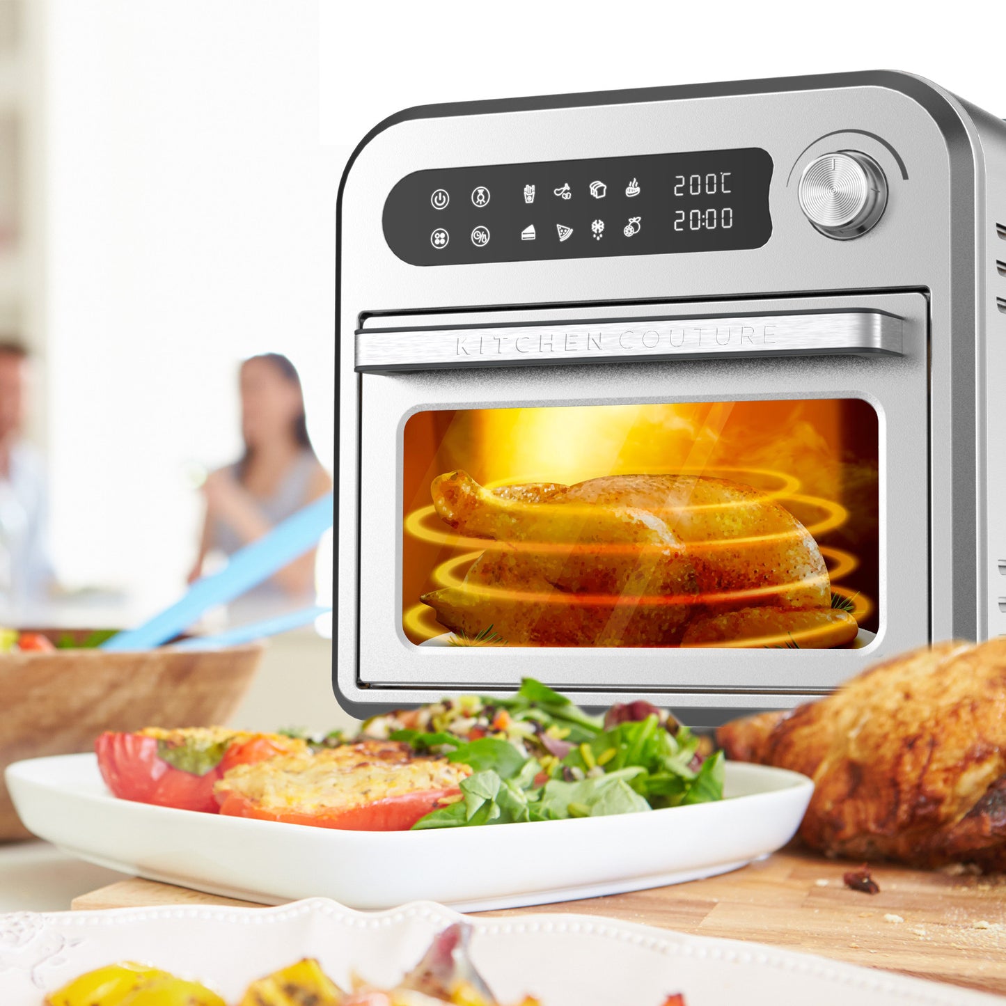Modern oven with food inside, surrounded by a table with a plate of salad and bread.
