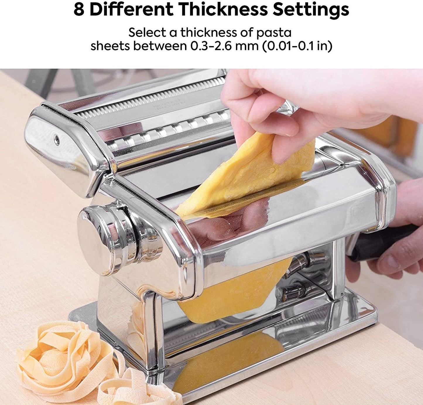 Pasta maker with a hand selecting a thickness setting, surrounded by fresh pasta sheets.