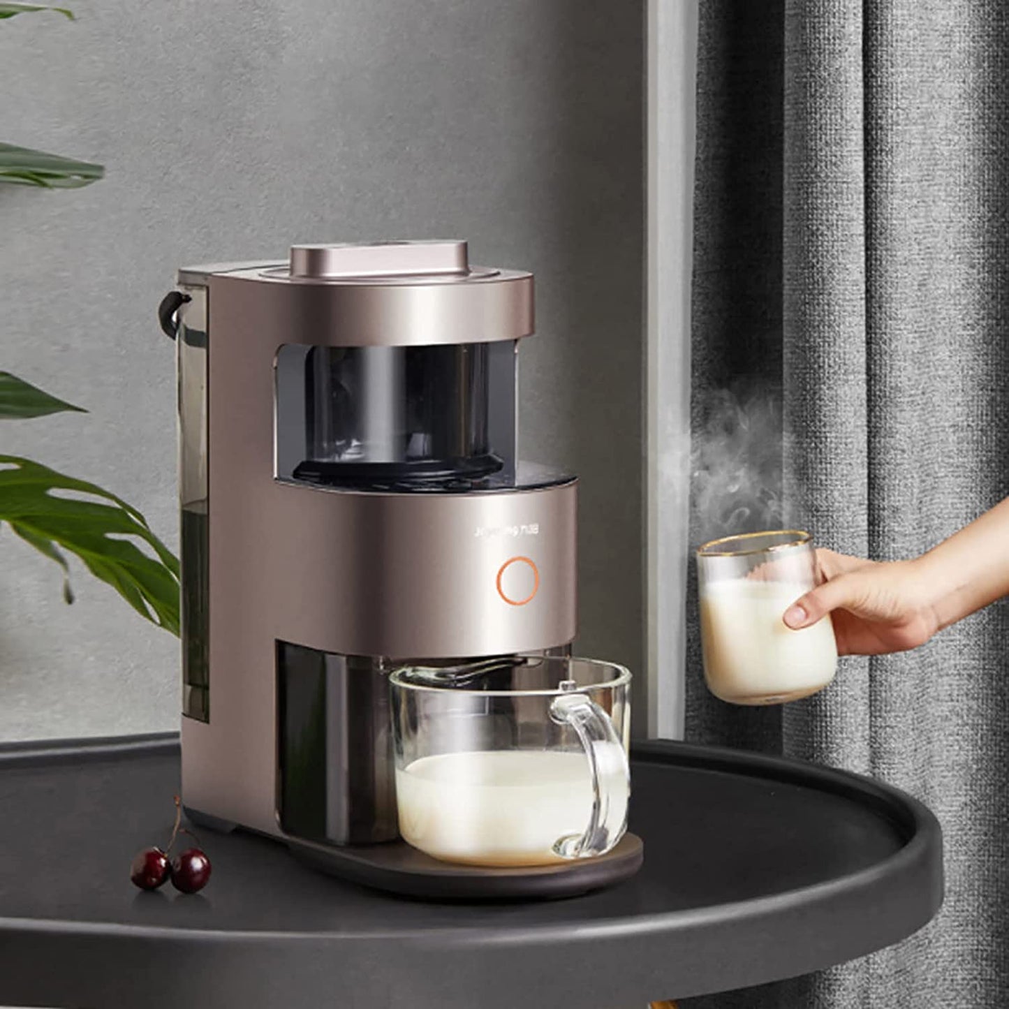 Coffee machine making a cup of coffee on a tray with a hand holding a glass of milk.