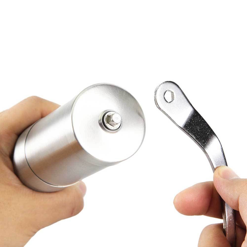 Metallic door handle and lock mechanism held by a hand against a white background