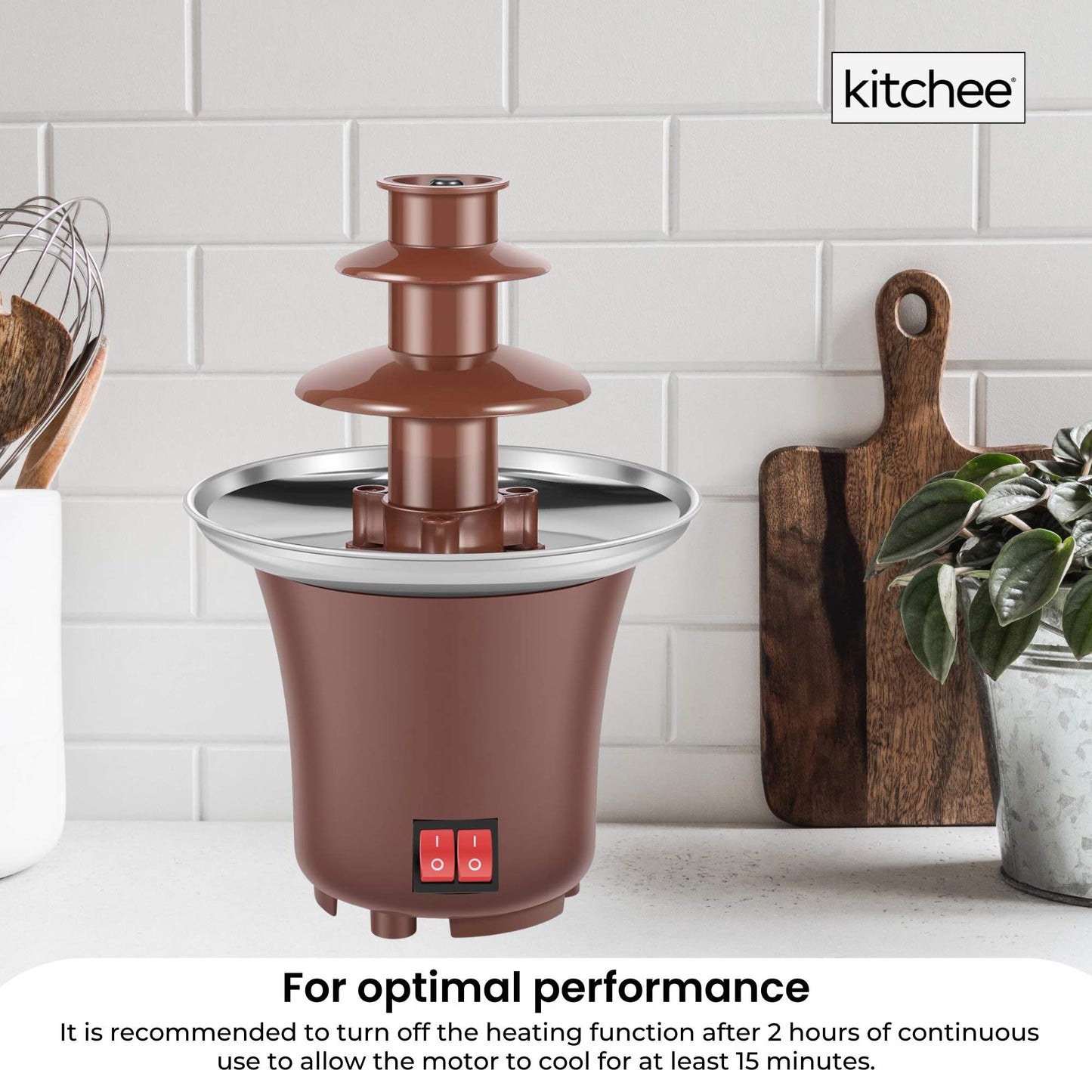 Brown chocolate fountain on a kitchen counter with 'kitchee' branding.