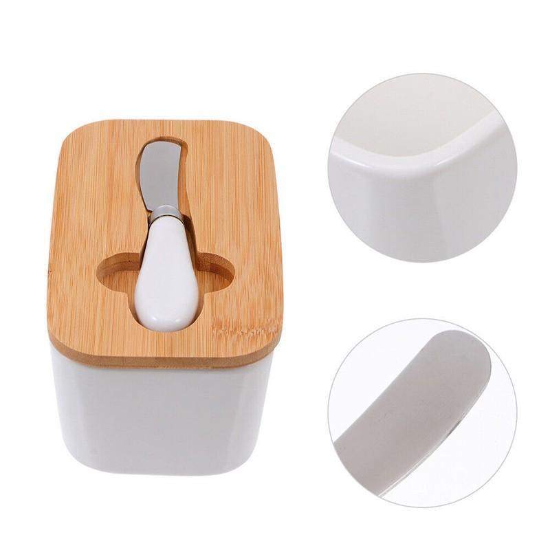 White ceramic container with wooden lid and knife, on a white background