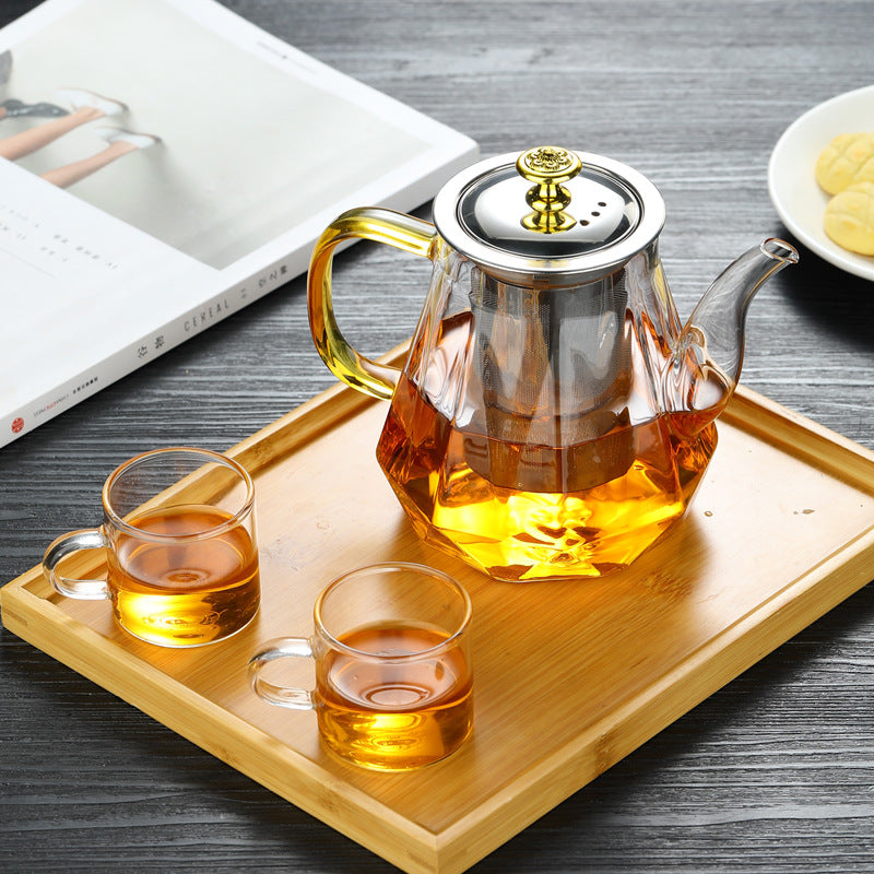 Tea set with glass teapot and cups on a wooden tray