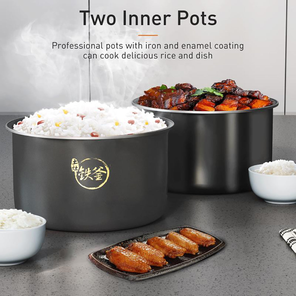 Two black inner pots with cooked rice and dish on a gray surface.