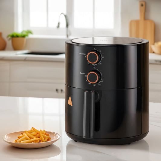 Black air fryer on a kitchen counter with a plate of fries
