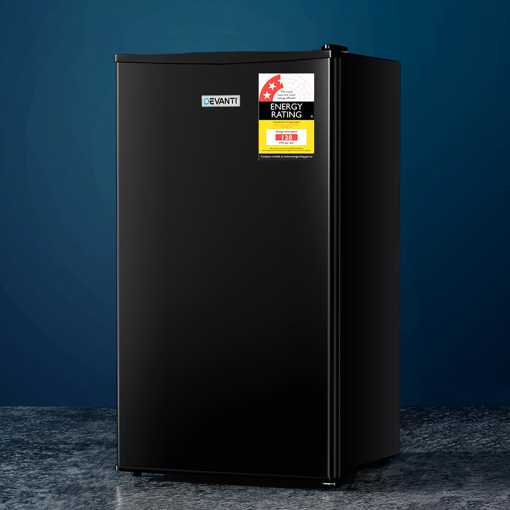 Black refrigerator with energy rating labels on a dark blue background