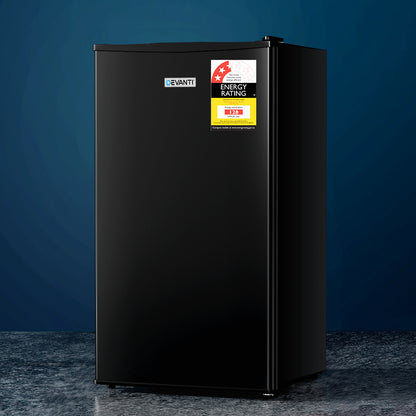 Black refrigerator with energy rating labels on a dark blue background