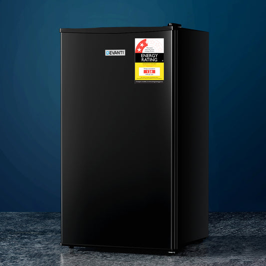 Black refrigerator with energy rating labels on a dark blue background