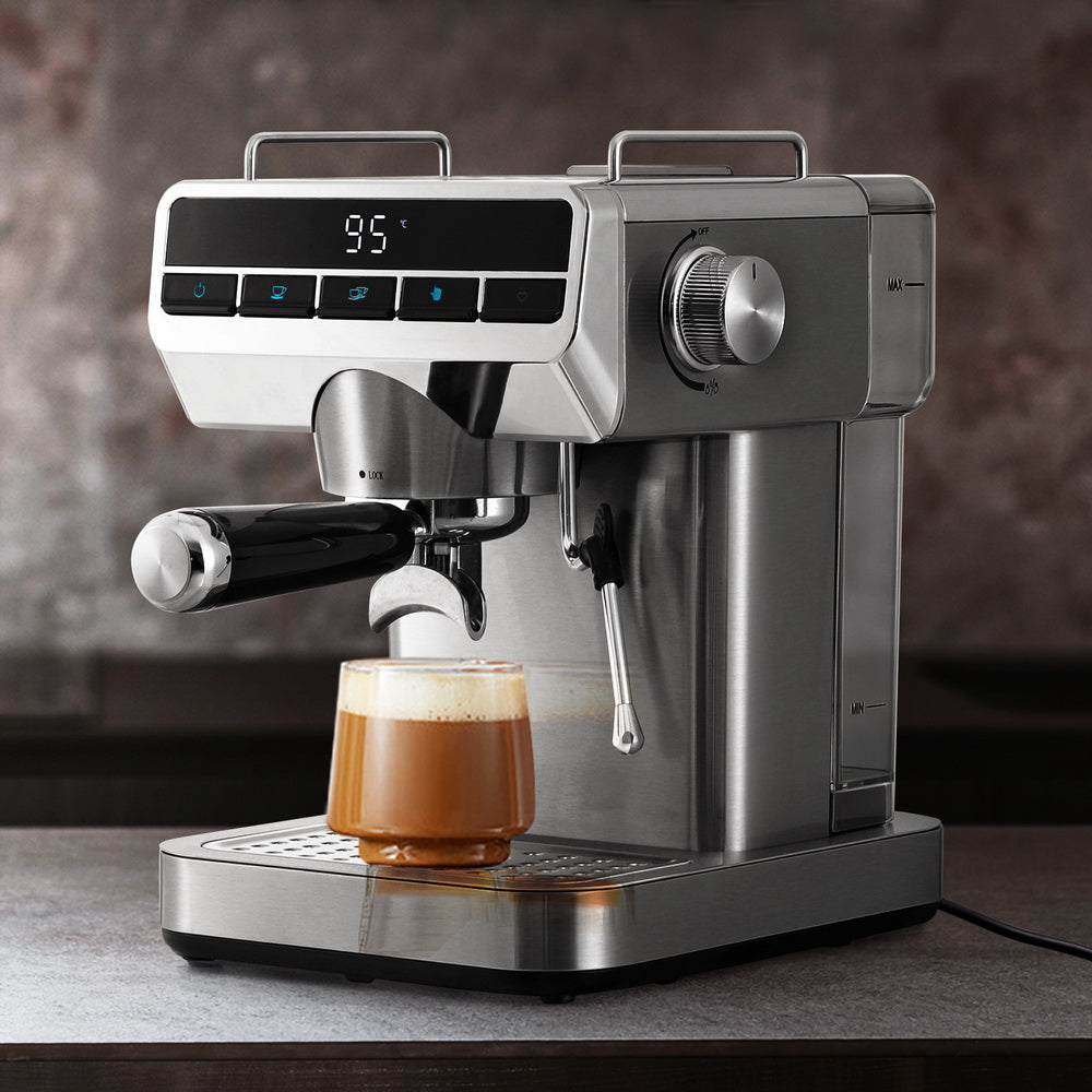 Silver espresso machine with a glass of coffee on a wooden surface