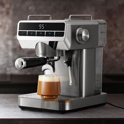 Silver espresso machine with a glass of coffee on a wooden surface