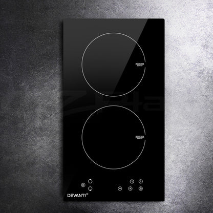 Black induction cooktop with two heating elements on a gray textured background