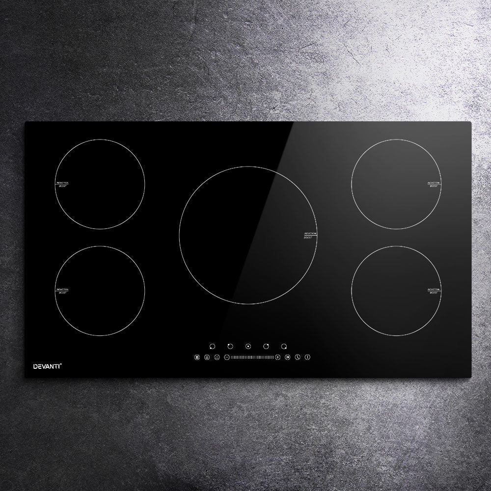 Black induction cooktop with four heating zones on a gray countertop