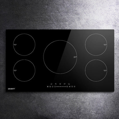 Black induction cooktop with four heating zones on a gray countertop