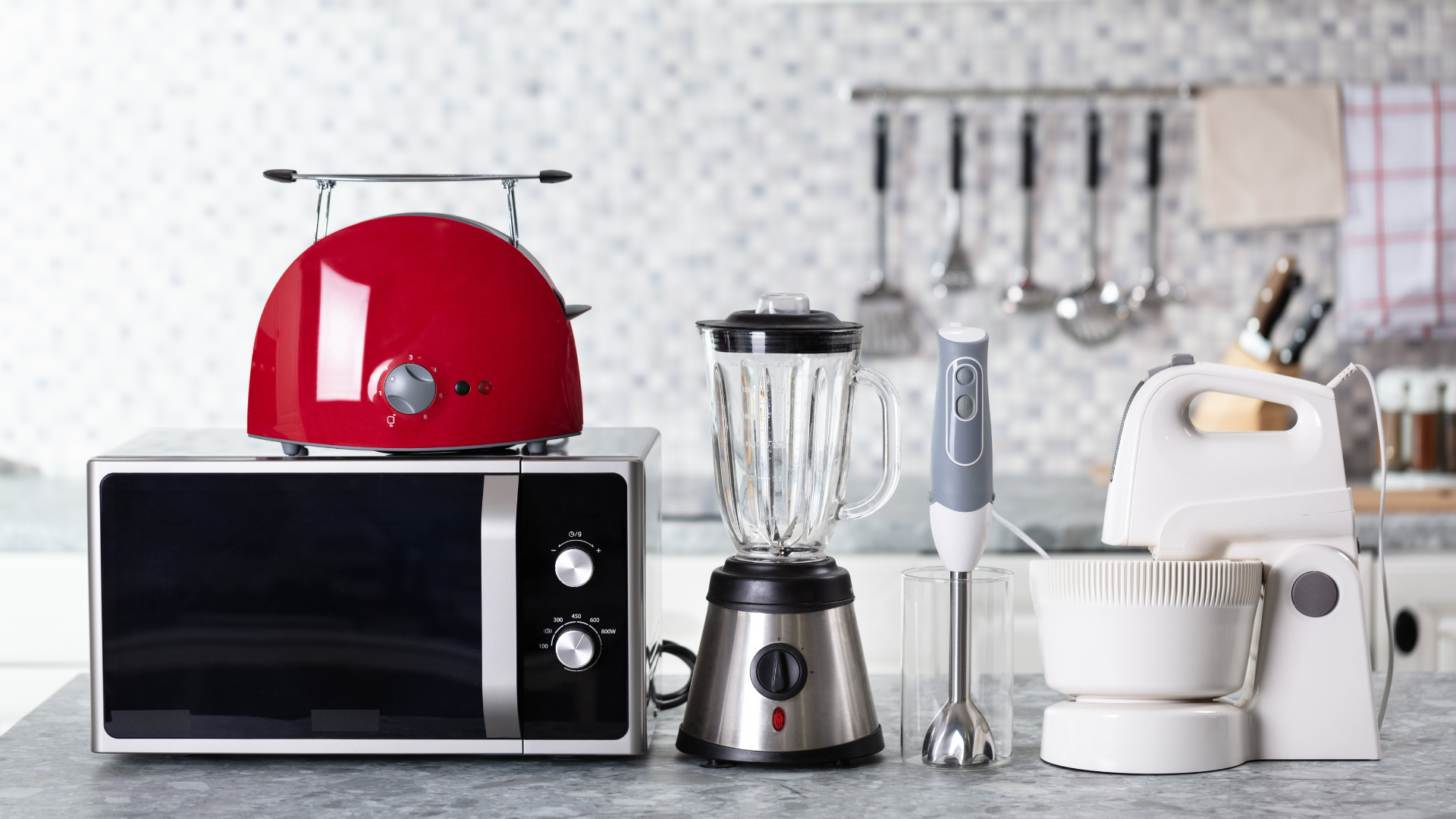 Kitchen appliances including a red toaster, microwave, blender, and mixer on a kitchen counter.