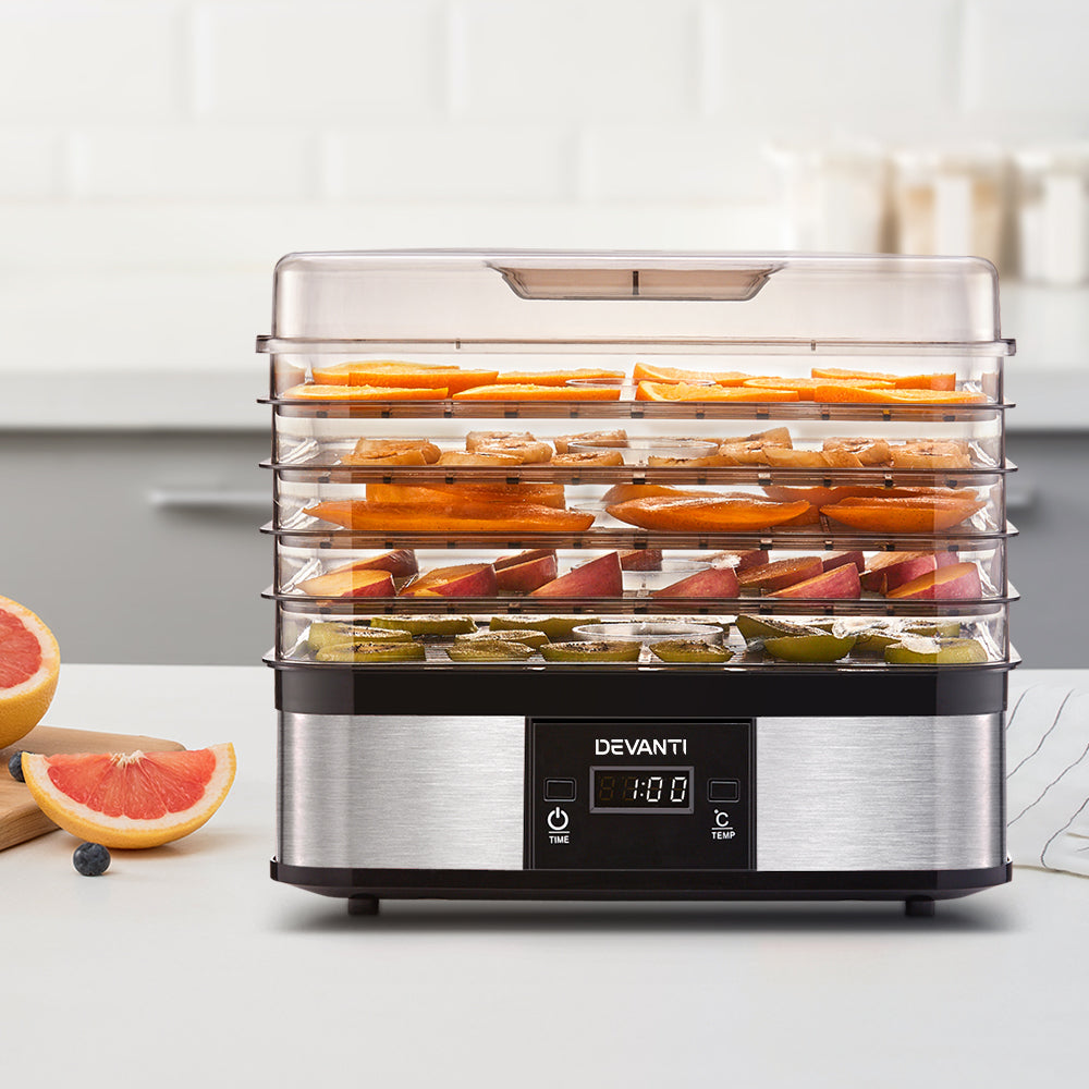 Sliced fruits being dehydrated on the five trays, showcasing healthy snack preparation.