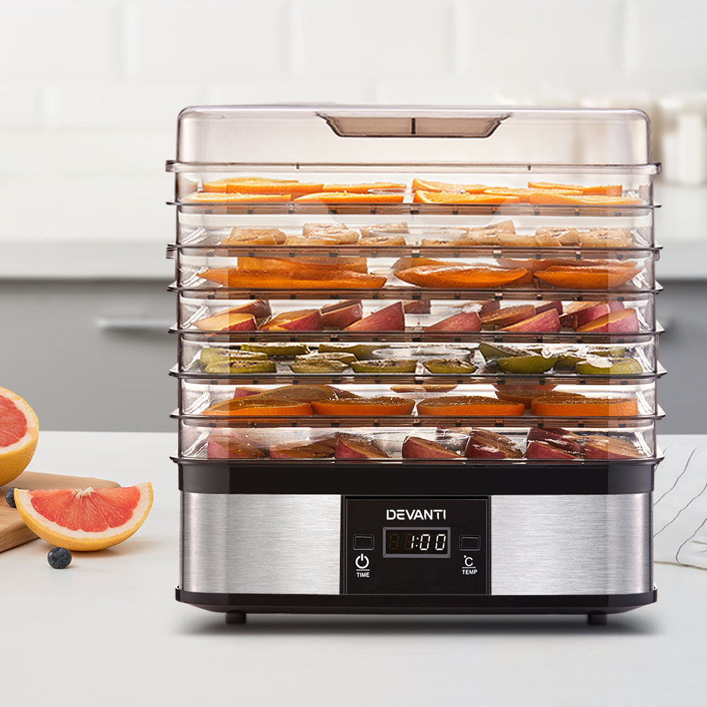 Multiple trays filled with sliced fruit visibly drying inside the machine.