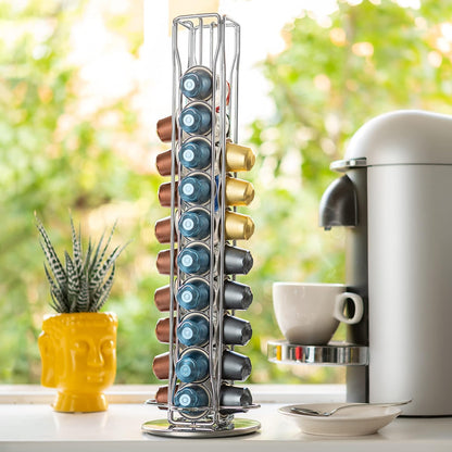 Stack of coffee capsules on a stand next to a coffee machine and cup.