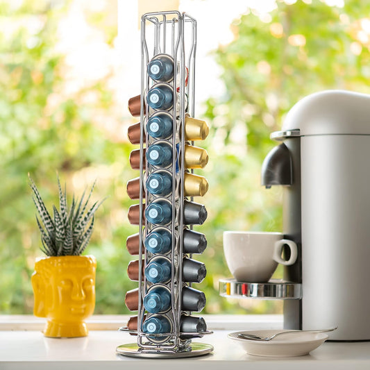 Stack of coffee capsules on a stand next to a coffee machine and cup.