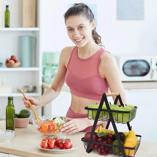 Woman in a kitchen preparing a salad with fruits and vegetables.