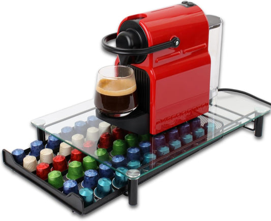 Red coffee machine with a glass of coffee and colorful capsules on a white background
