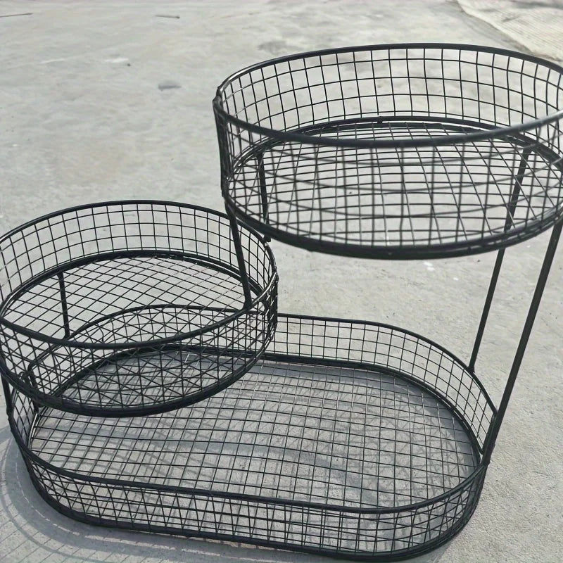 Black wire basket with multiple tiers on a concrete surface