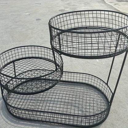 Black wire basket with multiple tiers on a concrete surface