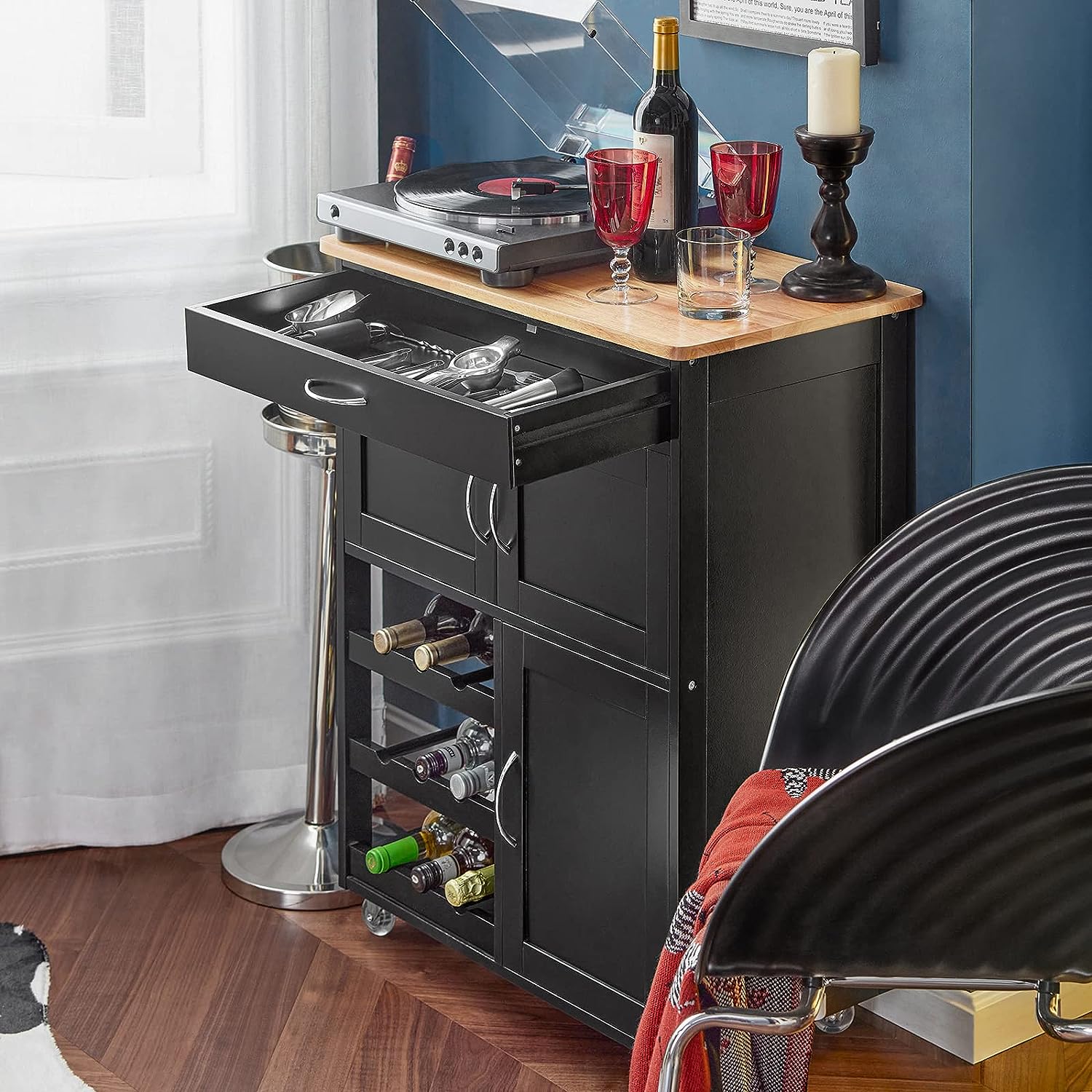 Black kitchen island with wine bottles and glasses in a home setting