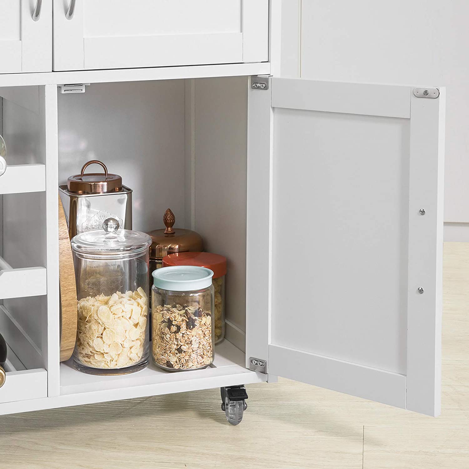 Open kitchen cabinet with jars inside, showing storage solution.