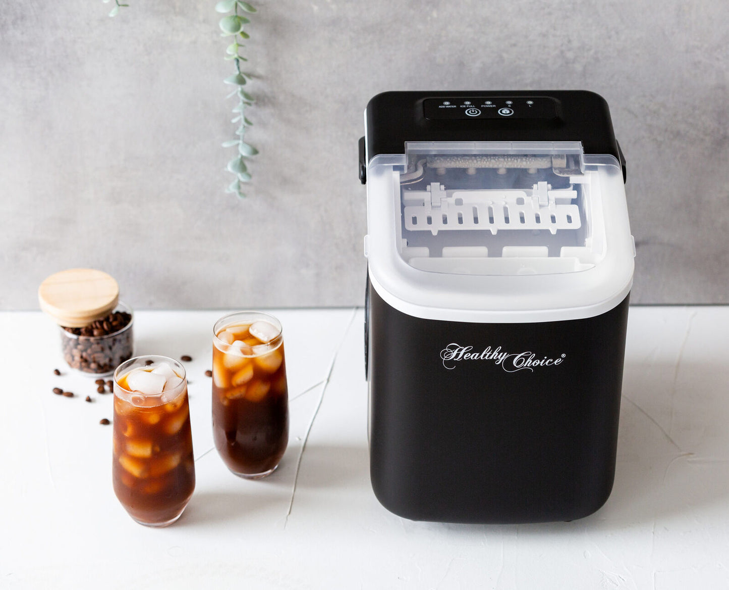 Black ice cube maker with 'Healthy Choice' branding on a white surface with iced coffee drinks.