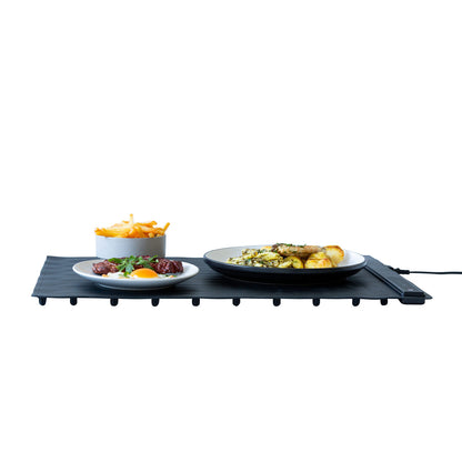 Black portable grill with plates of food on a white background