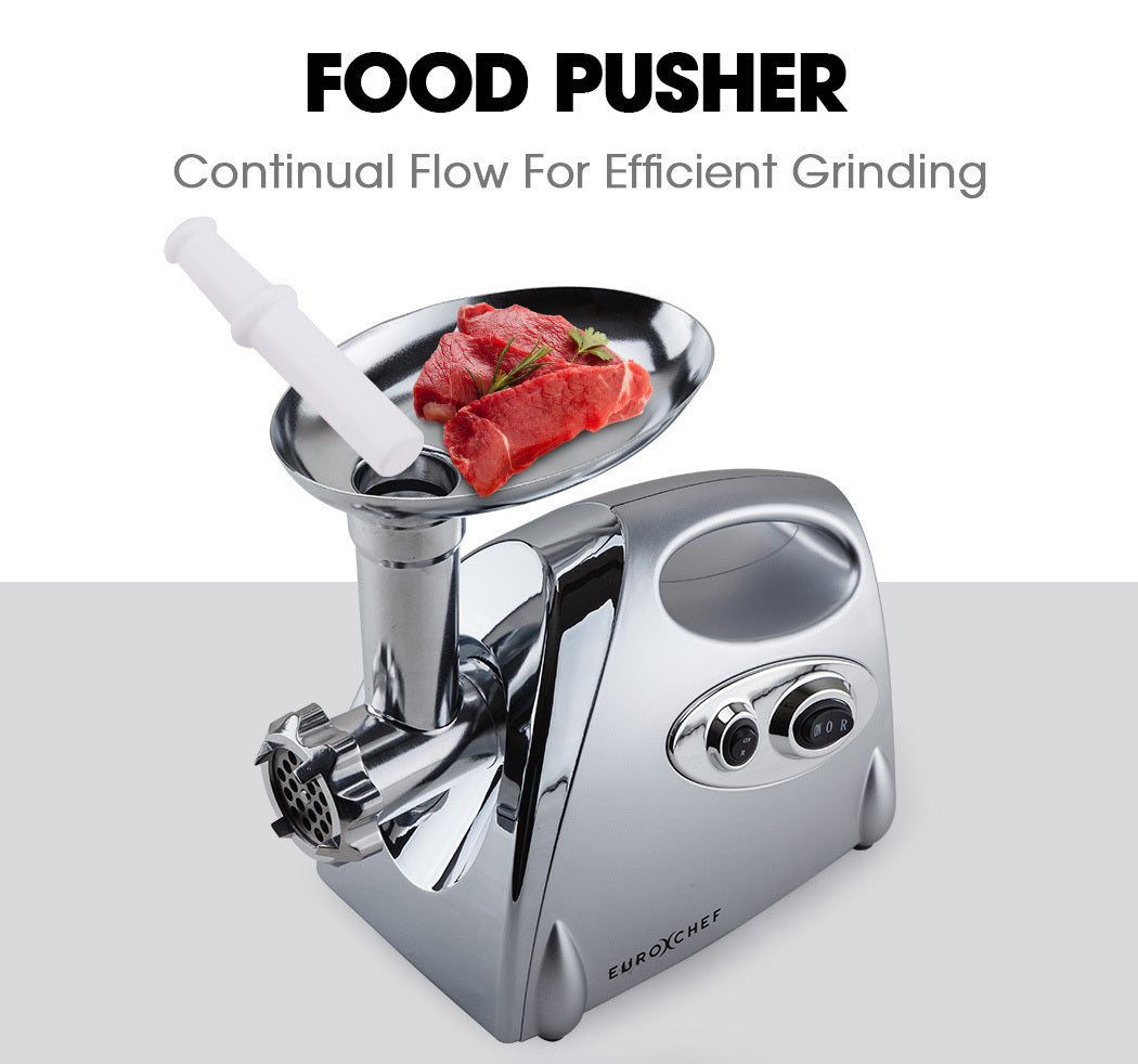 Metallic food grinder with a food pusher and ground meat on a white background