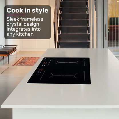 Modern kitchen with a black induction cooktop on a white countertop, featuring text about frameless crystal design.