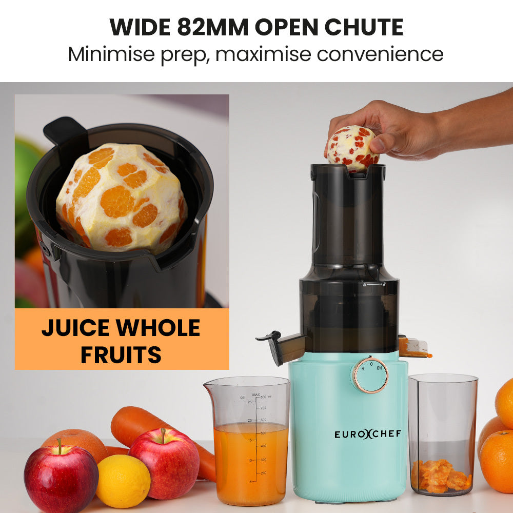 Turquoise juicer with fruits and juice, highlighting wide open chute feature.