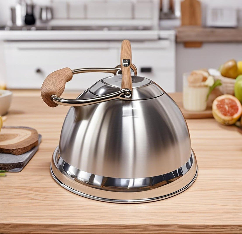 Stainless steel kettle with wooden handle on a kitchen counter