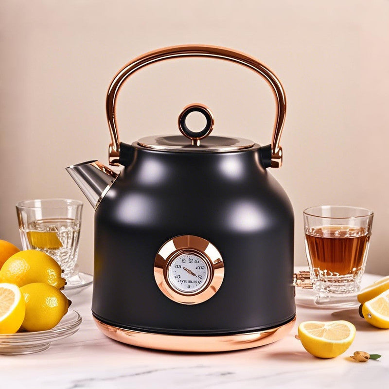Black electric kettle with copper accents on a table with lemons and tea glasses.