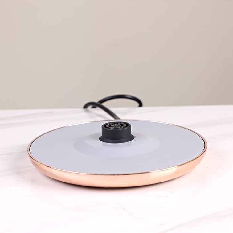 Ceramic frying pan with a black handle on a light surface