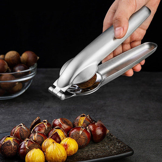Hand using a chestnut opener on roasted chestnuts with a dark background