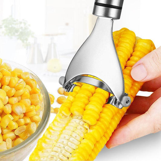 Corn shucker being used on a corn cob with a bowl of corn kernels on a white background