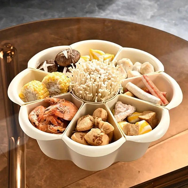 White segmented container with various food items on a reflective surface