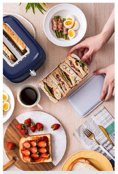 Breakfast scene with sandwiches, toast, coffee, and fruit on a table.