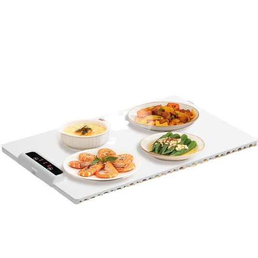 Electric heating pad with four plates of food on a white background