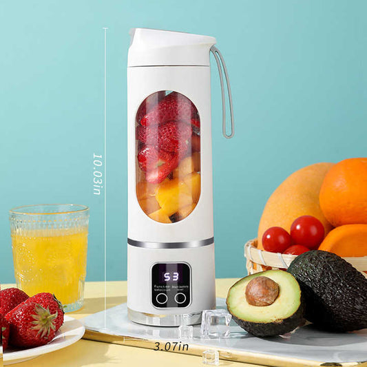 Portable blender with fruits and a glass of juice on a table