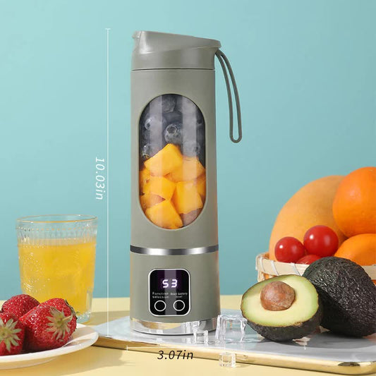 Portable blender with fruits and a glass of juice on a light blue background