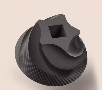 Black plastic component with square hole on beige background